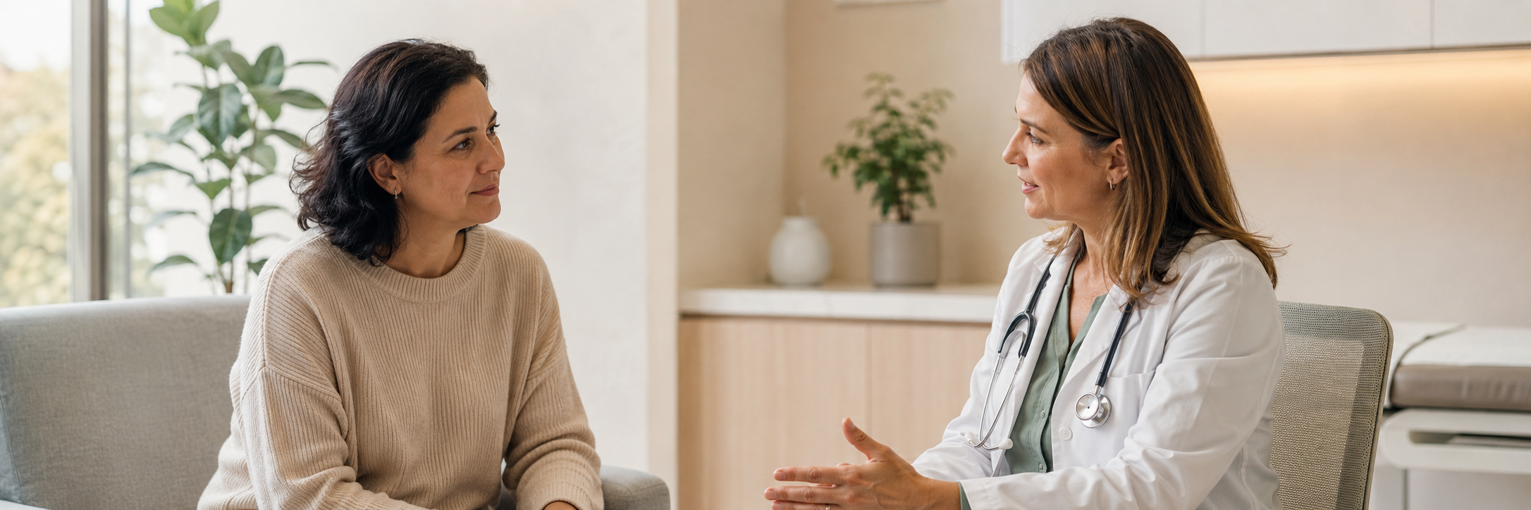 Una paciente conversa con su oncóloga en una consulta luminosa y tranquila